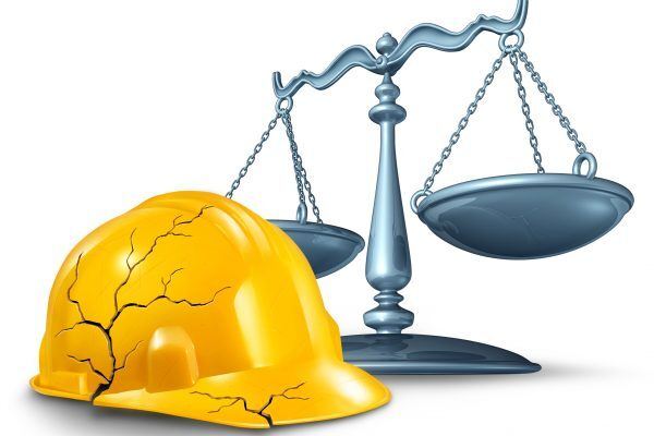 broken hard hat next to the scales of justice