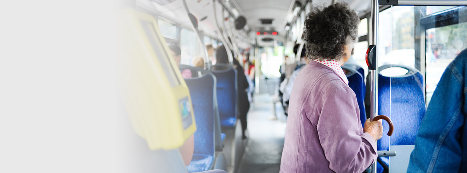 elderly woman standing in public transit bus